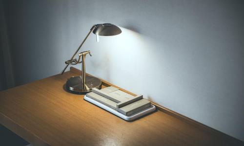 a desk with a lamp and two books on it at Wonju City Hotel HYEOKSIN in Wonju