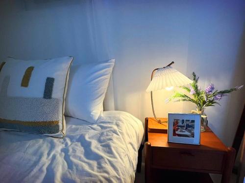 a bedroom with a bed and a night stand with a lamp at Clean & All new - Songridan-gil, Seokchon Lake, Lotte World, KSPO Dome, Olympic Park, Han River, Asan Hospital, Coex in Seoul