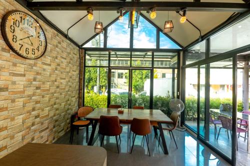 a dining room with a large clock on a brick wall at TOBEDzZ HOTEL in Ranong