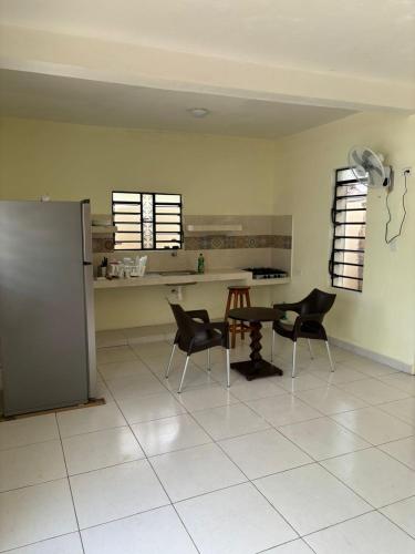 a kitchen with a table and chairs and a refrigerator at Casa del cenote in Valladolid
