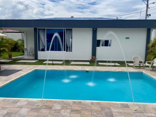 a house with a blue swimming pool in front of it at Cabañas Compostela gigante in Gigante