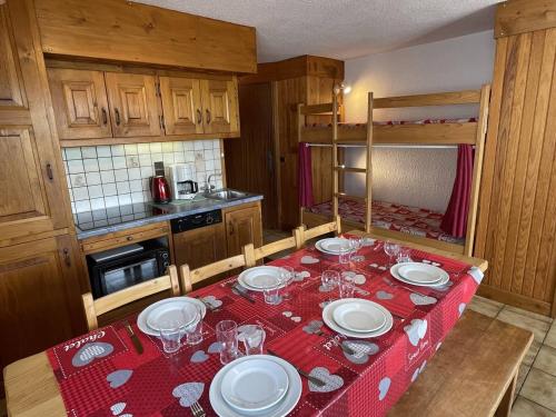 une cuisine avec une table avec des assiettes et des verres à vin dans l'établissement Charmant T2 en Savoie, Pied des pistes, 7 pers. - FR-1-810-20, aux Saisies