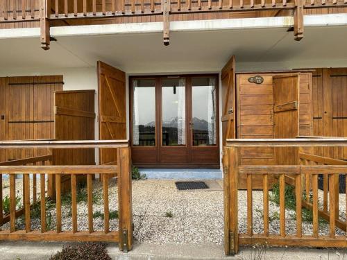 une grange avec des clôtures en bois et une porte avec des fenêtres dans l'établissement Appartement cosy 2 pièces - Proche pistes - Terrasse sud - 4 pers - FR-1-810-24, aux Saisies