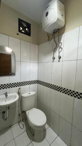 a bathroom with a toilet and a sink at De Nusantara Hotel Syariah in Medan
