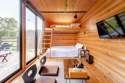 a room with a bed and a tv in a house at Almin Base 全室プライベートサウナ付きの宿 in Minami Alps