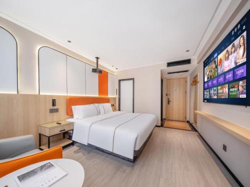 a hotel room with a bed and a tv at Yiwu Yunjing Hotel in Yiwu