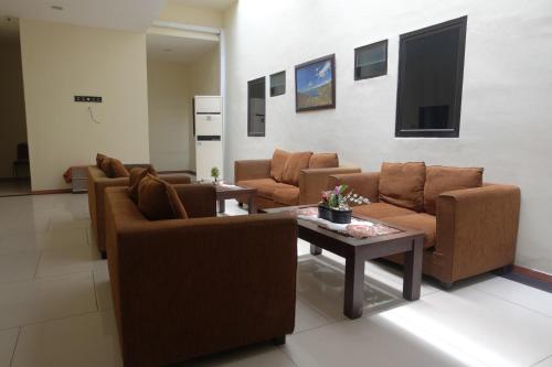 Una sala de estar con sofás y una mesa de café. en De Nusantara Hotel Syariah, en Medan