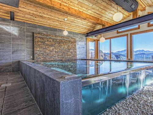 - une piscine dans une maison avec des montagnes dans l'établissement Appartement 4 pièces aux Saisies avec SPA, parking, accessible PMR - FR-1-810-4, aux Saisies