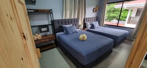 two beds in a bedroom with blue comforters at Ballena Rey Hotel in Uvita