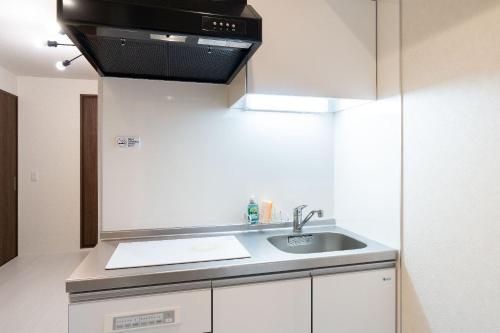 a kitchen with a sink and a microwave at Laurea Tower Ikebukuro in Tokyo