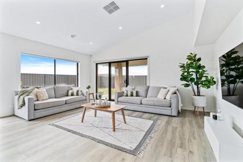a living room with two couches and a table at Yarrawonga Getaway in Yarrawonga