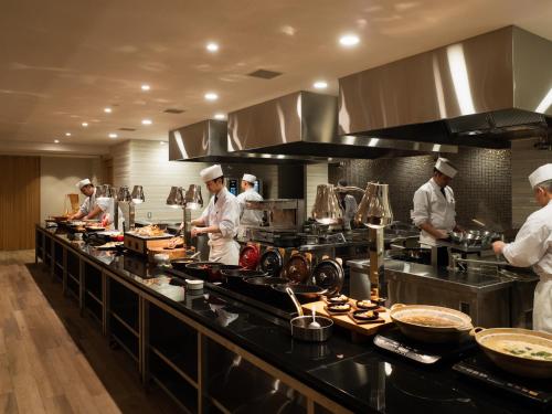 a group of chefs in a kitchen preparing food at 層雲閣 in Kamikawa