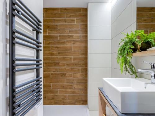 La salle de bains est pourvue d'un lavabo blanc et d'un mur en briques. dans l'établissement Appartement haut de gamme 10 pers, Spa & parking, Les Saisies - FR-1-810-2, aux Saisies