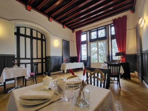 une salle à manger avec tables, chaises et fenêtres dans l'établissement Chambres d'hôtes de charme au Château avec jardin et petit-déjeuner inclus - FR-1-591-689, à Cluis