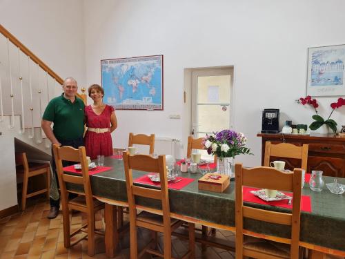 a man and a woman standing in front of a table at Ferme rénovée avec charme en Beauce, 4 chambres spacieuses, proche châteaux de la Loire - FR-1-590-459 in Cravant