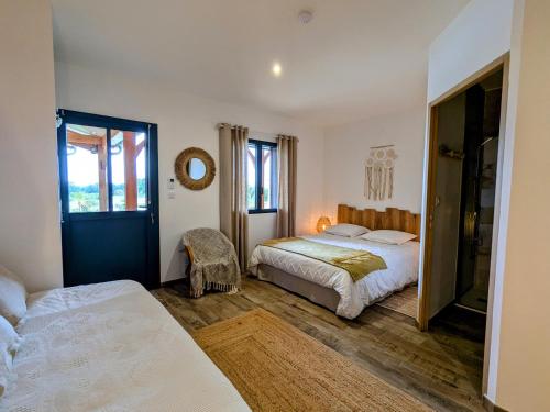 una camera da letto con due letti e uno specchio di Chambre Bohème avec piscine chauffée et Wi-Fi gratuit - FR-1-591-704 a Faverolles