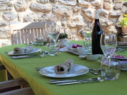 - une table verte avec une bouteille de vin et des verres dans l'établissement Chambre cosy avec bien-être, parking, wifi - Au cœur de l'Auvergne - FR-1-582-506, à Saint-Privat-dʼAllier