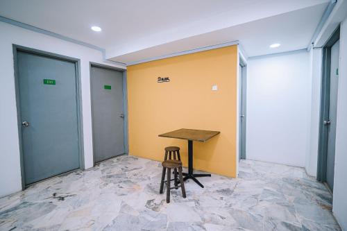 a wooden table in an empty room with a stool at Swing & Pillows - Seri Kembangan Selangor in Seri Kembangan
