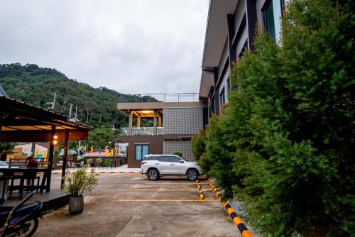 a car parked in a parking lot next to a building at TOBEDzZ HOTEL in Ranong