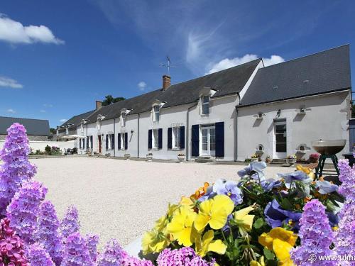 a white building with flowers in front of it at Chambres spacieuses près de Beaugency, petit-déjeuner inclus - FR-1-590-455 in Cravant
