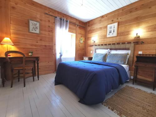 a bedroom with a bed and a table and a desk at Maison de campagne paisible avec terrasse et animaux admis - FR-1-582-505 in Sembadel