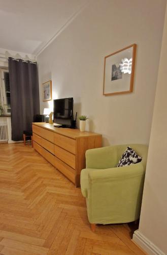 a living room with a green chair and a television at City Apartments Triangeln in Malmö