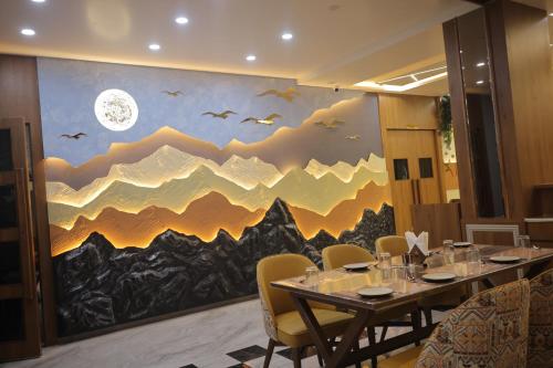 a dining room with a mural of mountains at Hotel Raghavji in Rādhanpur