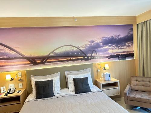 a bedroom with a bed with a painting on the wall at Cullinan Brasilia - Fabuloso apartamento da REDE PREMIUM 05 in Brasilia