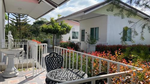 a patio with a table and chairs and a house at โฟร์วิลล่า เขาใหญ่ in Pak Chong