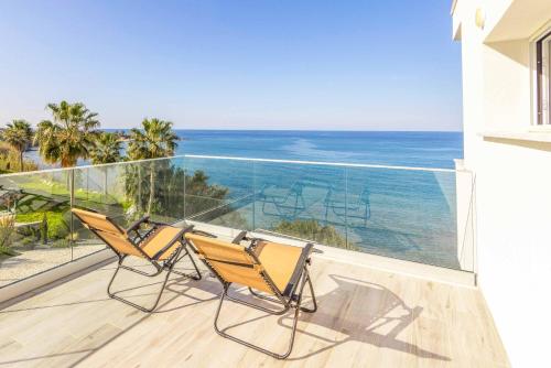 two chairs on a balcony with a view of the ocean at Pomos Seashore villa in Pomos