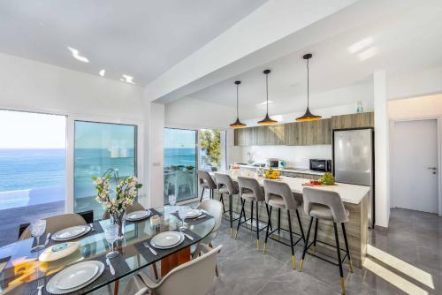 a kitchen and dining room with a glass table and chairs at Pomos Seashore villa in Pomos