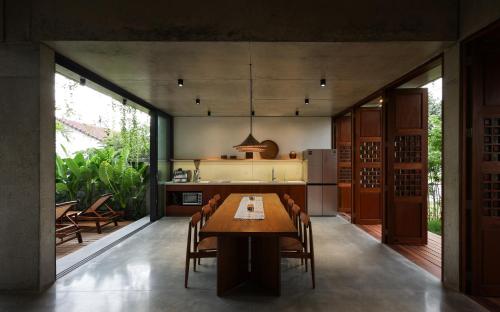 Una cocina con mesa y sillas y un refrigerador. en Nongnia Beach Villa, en Tân Thành (1)