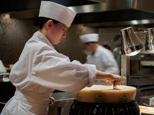a woman in a kitchen preparing a cake at 層雲閣 in Kamikawa