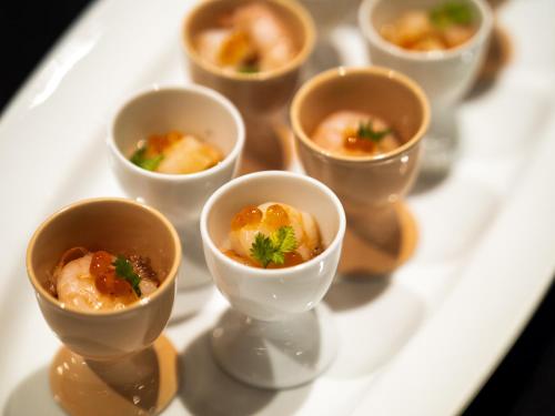 a white plate with small bowls of food on it at 層雲閣 in Kamikawa