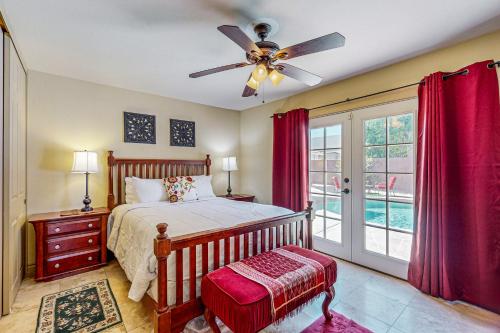 een slaapkamer met een bed en een plafondventilator bij Calle Quito Escape Permit# 217,228 in La Quinta