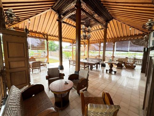a large pavilion with tables and chairs in a room at Joglo Bandulan Homestay Jogja in Ngemplak
