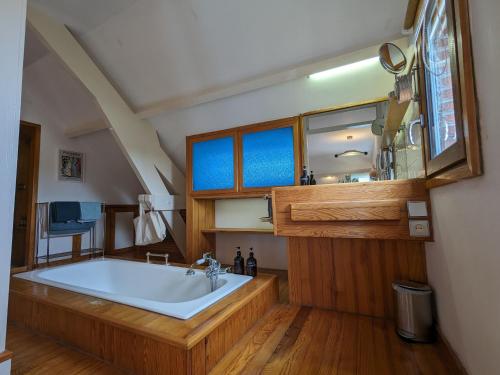 un bagno con ampia vasca e pavimenti in legno di Chambre calme avec Wifi et parking sécurisé, proche naturaleza - FR-1-590-501 a Presnoy