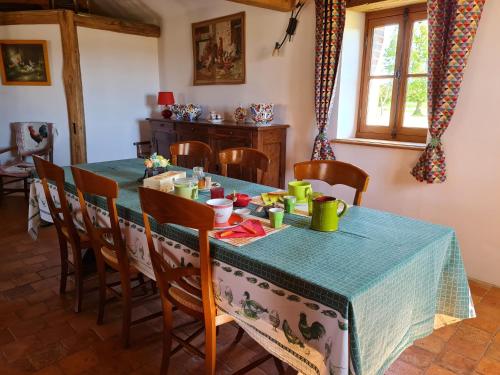 une salle à manger avec une table et un chiffon bleu dans l'établissement Chambre cosy à la ferme avec terrasse, parking et cuisine d'été - FR-1-590-476, à Bonnée
