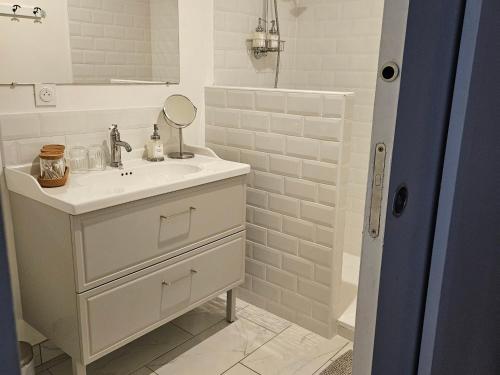 une salle de bain blanche avec un lavabo et un miroir dans l'établissement Chambre Chambord avec piscine chauffée et parking privatif - FR-1-590-484, à Messas
