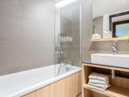La salle de bains est pourvue d'une baignoire avec douche et d'un lavabo. dans l'établissement Appartement 4 pièces avec SPA et parking - Les Saisies - FR-1-810-11, aux Saisies