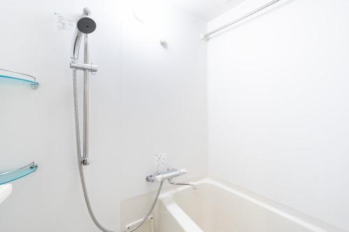 a shower in a white bathroom with a tub at PL Park Lane Shirokane Takanawa in Tokyo