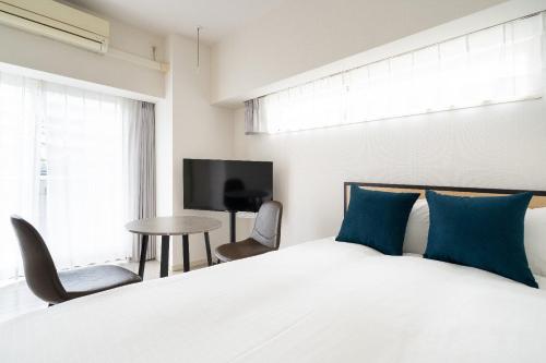 a bedroom with a bed and a tv and a table at PL Park Lane Shirokane Takanawa in Tokyo