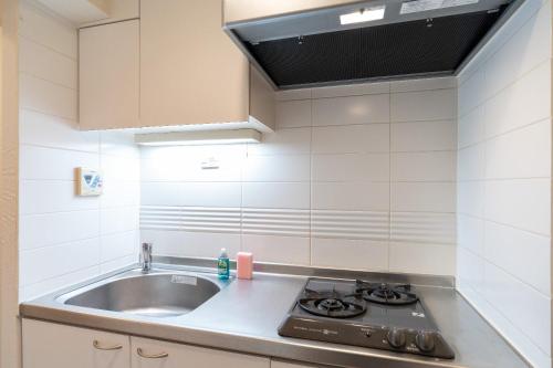 a kitchen with a sink and a stove at PL Park Lane Shirokane Takanawa in Tokyo
