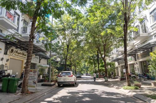 a white car parked on a street with trees at TPHomes Lakeview 122 in Ho Chi Minh City