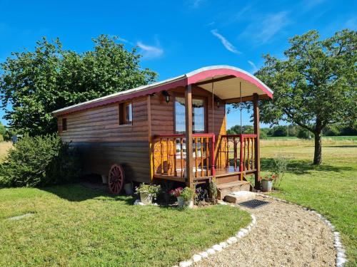 una cabina in legno con tetto rosso di Roulotte Esméralda: Séjour insolite au cœur de la nature, climatisée, parking privé, prêt de vélos - FR-1-590-502 a Bonnée