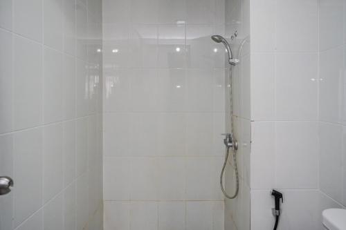 a bathroom with a shower with a glass door at Spacious and Nice 2BR at Casa De Parco Apartment By Travelio in Tangerang