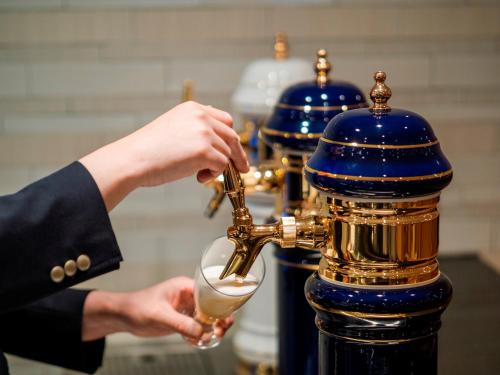 a person pouring a drink into a glass at 層雲閣 in Kamikawa