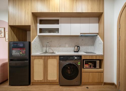 a kitchen with a washing machine and a sink at MOONLIT Suites Hotel by Luxe Paradise in Hanoi