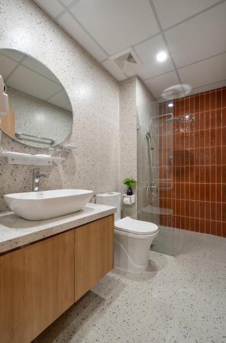 a bathroom with a sink and a toilet and a mirror at MOONLIT Suites Hotel by Luxe Paradise in Hanoi