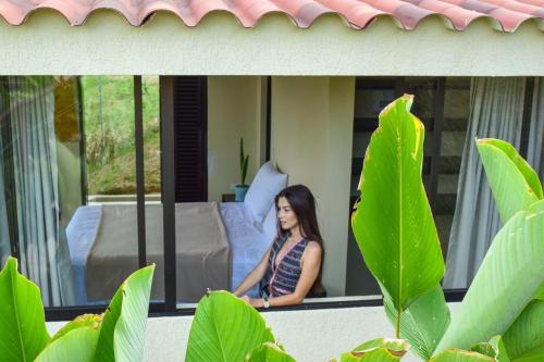 a woman sitting on the porch of a house at Pachakuti Eco-vida Hotel in Caicedonia
